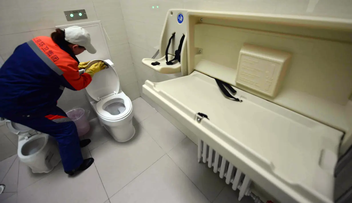 Petugas membersihkan toilet umum pertama yang dilengkapi Wi-fi, mesin ATM hingga tempat pengisian energi untuk ponsel dan mobil listrik di Beijing, Kamis (19/11). Toilet ini juga akan dibuka di pinggiran kota Beijing dan kota lain. (CHINA OUT AFP PHOTO)