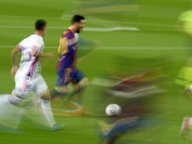 Striker Barcelona, Lionel Messi, menggiring bola melewati pemain Real Valladolid pada laga Liga Spanyol di Stadion Camp Nou, Selasa (6/4/2021). Barcelona menang dengan skor 1-0. (AP Photo/Joan Monfort)