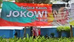 Warga berjalan di dekat baliho bertuliskan Terima Kasih Jokowi di Jalan Jenderal Sudirman, Jakarta Kamis (17/10/2024). (Liputan6.com/Angga Yuniar)