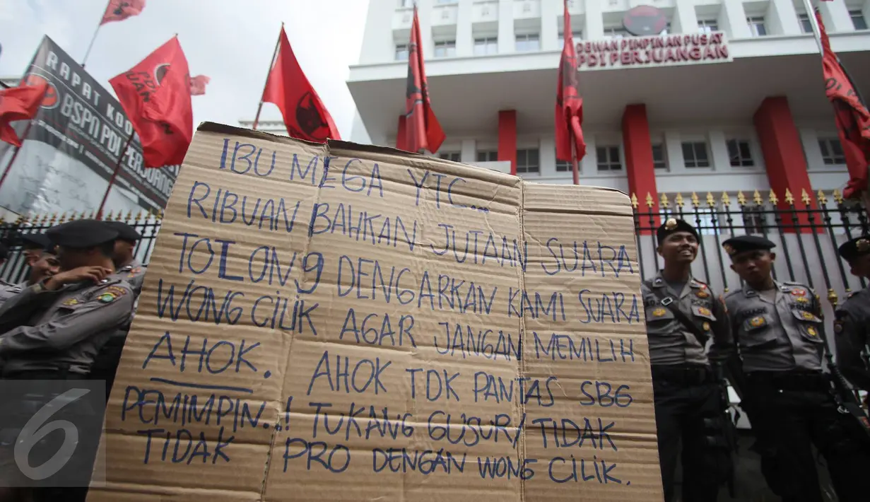 Massa menuliskan tuntutan mereka di kardus saat menggelar unjuk rasa di kantor DPP PDIP, Jakarta, Rabu (7/9). Mereka meminta PDIP tidak mengusung Ahok pada Pilgub DKI, namun mengajukan Wali Kota Surabaya Tri Rismaharini. (Liputan6.com/Immanuel Antonius)