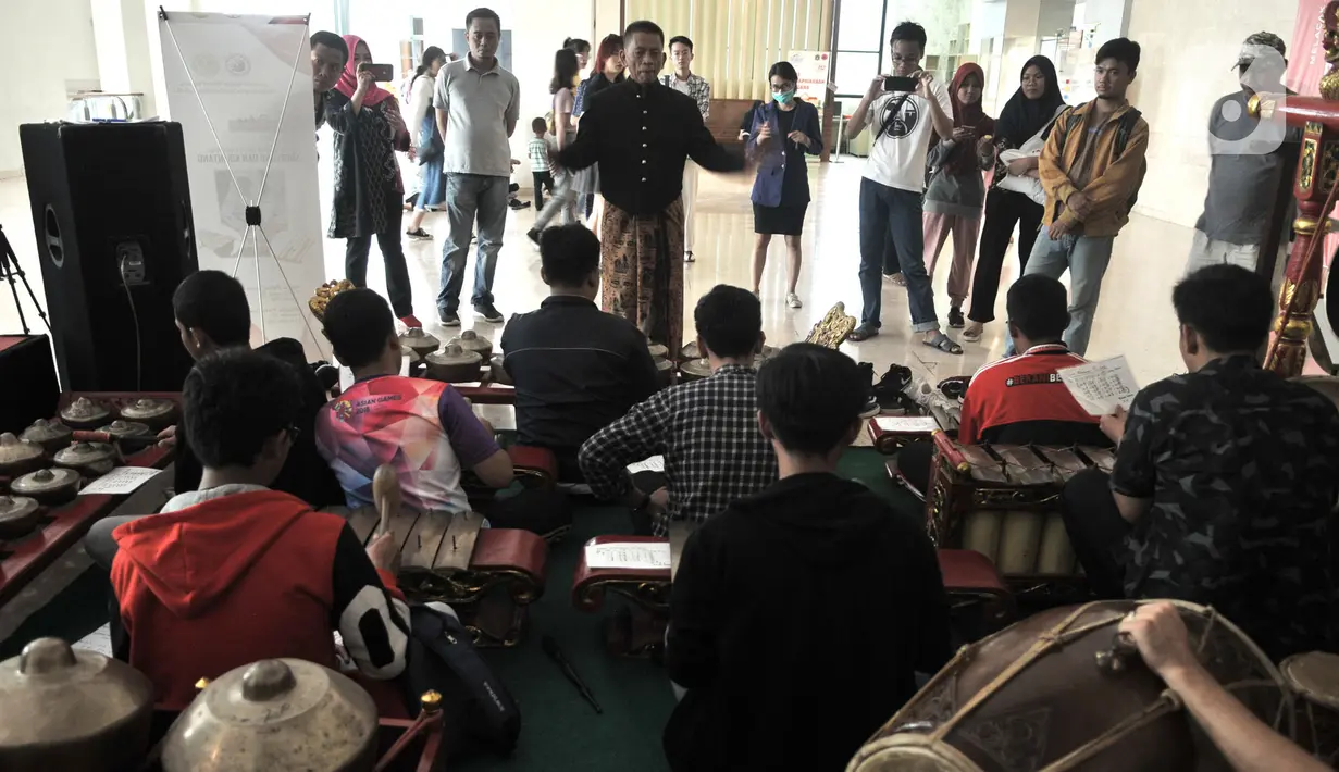 Pengunjung berlatih menjadi Nayaga atau penabuh gamelan saat lokakarya "Suara Dari Masa Lalu" di Museum Nasional, Jakarta, Minggu (22/12/2019). Lokakarya ini digelar dari 15 Desember 2019 hingga 5 Januari 2020. (merdeka.com/Iqbal S. Nugroho)