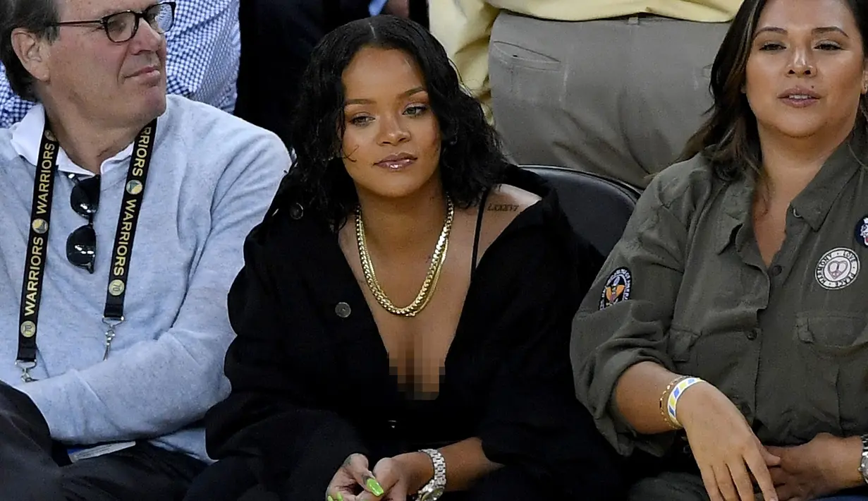 Penyanyi Rihanna saat menyaksikan pertandingan gim pertama Final NBA 2017 antara Golden State Warriors melawan Cleveland Cavaliers di Oracle Arena, Oakland, (1/6). Rihanna tampil dengan busana berwara hitam. (Thearon W. Henderson/Getty Images/AFP)