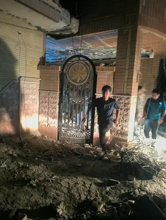 Sejumlah orang memeriksa sebuah bangunan yang menurut media Iran rusak akibat serangan AS di Kuhestak, Iran selatan,  Rabu dini hari, 2 September 2026. (Masoud Mohammadi/Tasnim News Agency via AP)