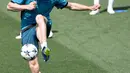 Penyerang Real Madrid, Gareth Bale berusaha mengontrol bola saat latihan di Madrid, Spanyol (22/5). Madrid akan melawan Liverpool pada babak final Liga Champions di Stadion NSC Olimpiyskiy di Kiev. (AFP Photo/Gabriel Bouys)