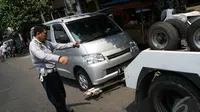 Seorang petugas Dishub memberikan instruksi bahwa derek pengait sudah terpasang dengan baik dan siap untuk diangkut, Jakarta, Kamis (18/9/2014) (Liputan6.com/Faizal Fanani)