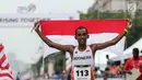 Pelari Indonesia Agus Prayogo membawa Bendera Merah Putih usai melakukan trek maraton SEA Games XXIX di di Putrajaya, Kuala Lumpur, Malaysia, Sabtu (19/8). Agus berhasil meraih medali perak nomor lari marathon cabang atletik. (Liputan6.com/Faizal Fanani)