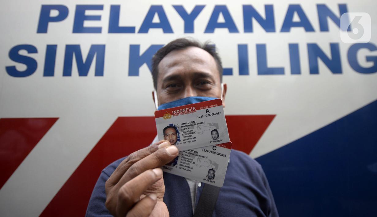 Warga menunjukkan SIM di Pelayanan SIM Keliling, Tangerang Selatan, Banten, Jumat (7/8/2020). Ditlantas Polda Metro Jaya memberi dispensasi bagi pemilik SIM yang masa berlakunya habis di masa pandemi COVID-19 bisa memperpanjang sampai akhir Agustus 2020. (merdeka.com/Dwi Narwoko)