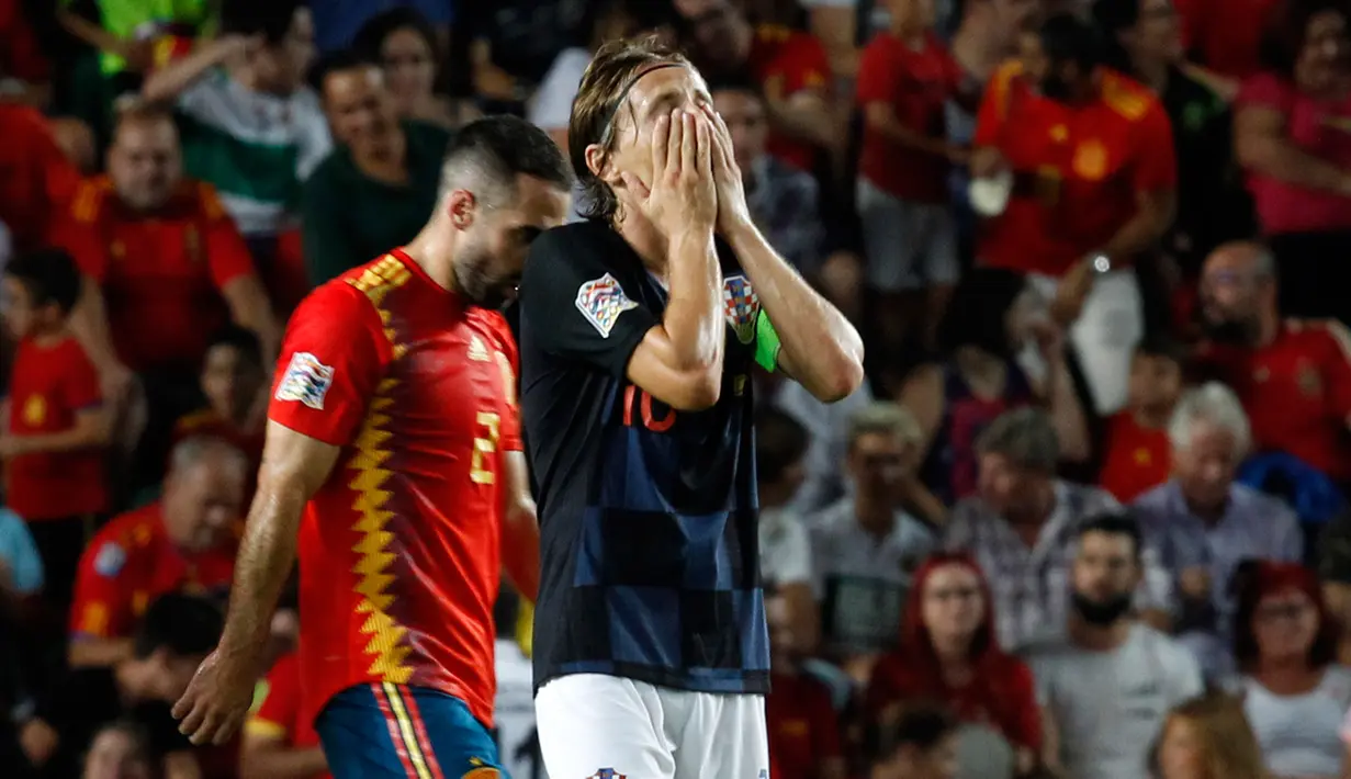 Gelandang Kroasia, Luka Modric menutupi wajahnya setelah bek Spanyol, Sergio Ramos mencetak gol kelima selama pertandingan UEFA Nations League di stadion Manuel Martinez Valero, Spanyol (11/9). Spanyol menang 6-0 atas Kroasia. (AP Photo/Alberto Saiz)