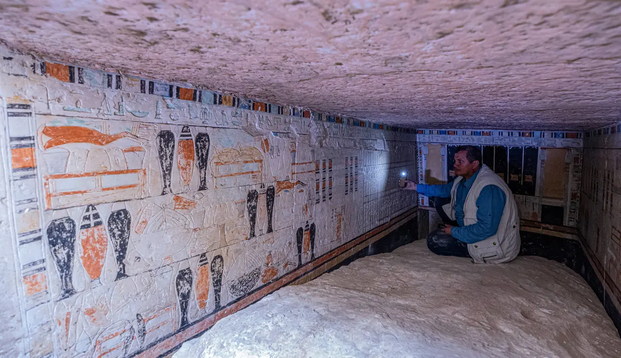 Seorang arkeolog berbicara kepada anggota media di dalam makam Beti, salah satu dari lima makam Firaun kuno di situs arkeologi Saqqara, Kairo, Mesir (19/3/2022). Para arkeolog menemukan lima makam di timur laut piramida Raja Merenre I, yang memerintah Mesir sekitar tahun 2270 SM. (AFP/Khaled Desouki