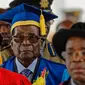 Presiden Zimbabwe, Robert Mugabe tiba untuk menghadiri upacara wisuda mahasiswa Universitas Terbuka Zimbabwe di pinggiran Harare, Jumat (17/11). Pasca berstatus sebagai tahanan rumah, untuk pertama kali Mugabe muncul di muka publik. (AP Photo/Ben Curtis)