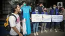 Sejumlah mahasiswa UNY membawa baju dansa saat menggelar aksi di depan Gedung Kemendikbud, Jakarta, Jumat (10/2/2023). Dengan memaksa masuk untuk melakukan aksi di dalam lingkungan Kemendikbud, mahasiswa UNY memberikan baju dansa sebagai bentuk protes terkait mahalnya biaya kuliah di Indonesia. (Liputan6.com/Faizal Fanani)