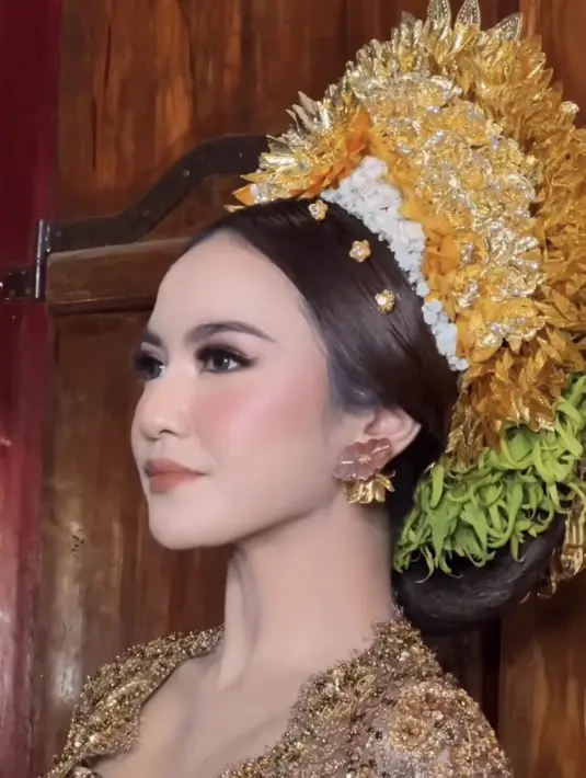 Tampilan Mahalini semakin memesona dengan gaya rambut khas pengantin Bali. Mahalini tampil dengan gelungan payas agung ditambah hairclip bunga emas.  [@ochiipramita]
