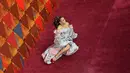 Penyanyi Andra Day berpose untuk fotografer sambil rebahan di atas karpet merah penghargaan Piala Oscars 2018 di Dolby Theatre, Los Angeles, Minggu (4/3). Pose Andra Day yang lain dari pada lain tersebut menyita perhatian. (Robyn Beck / AFP)