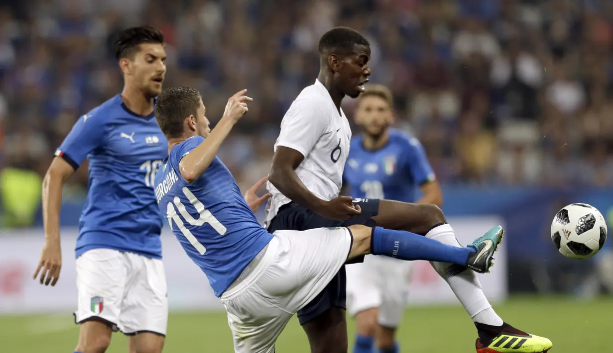 Pemain Italia, Jorginho berusaha menghalau bola dari kaki pemai Prancis, Paul Pogba pada laga uji coba di Allianz Riviera stadium, Nice, (1/6/2018). Prancis menang 3-1. (AP/Claude Paris)