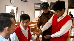 Warga negara Thailand, Prakob Seetasang dan Adison Phonlamat bersiap menjalani persidangan kasus penyelundupan narkoba di pengadilan Denpasar, Bali (23/9/2019). Keduanya diduga berusaha menyelundupkan 1 kg metamfetamin ke Bali. (AFP Photo/Sonny Tumbelaka)