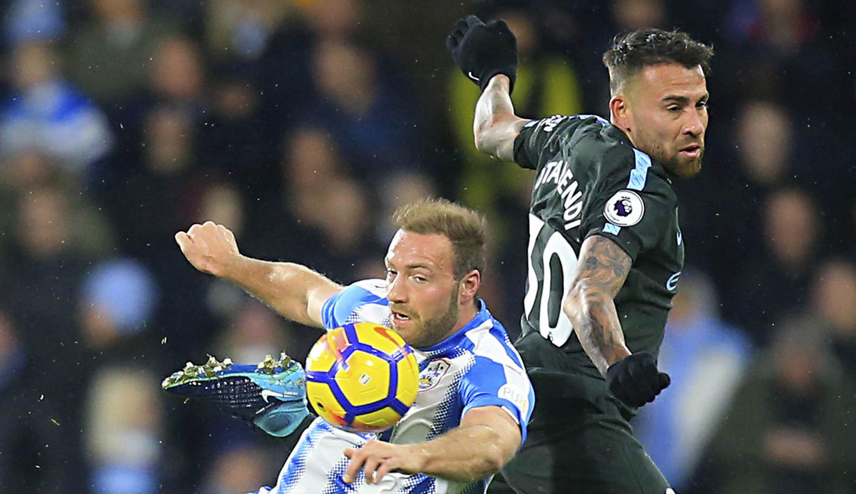 Striker Huddersfield, Laurent Depoitre, berebut bola dengan bek Manchester City, Nicolas Otamendi, pada laga Premier League di Stadion John Smith, Huddersfield, Minggu (26/11/2017). Huddersfield kalah 1-2 dari City. (AP/Danny Lawson)