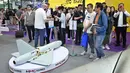 Pengunjung terlihat berdiri di samping model drone UAV Winged Tiger H1500 di stan Micro Multi Copter (MMC) selama Drone World Congress (DWC) di Shenzhen pada 21 Mei 2026. (HECTOR RETAMAL/AFP)