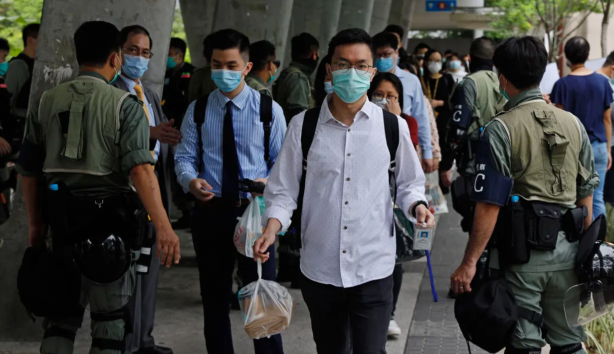 Polisi anti huru hara memeriksa kartu identitas orang-orang di dekat Gedung Dewan Legislatif di Hong Kong, Rabu (27/5/2020). Penjagaan ekstra dilakukan menimbang kemungkinan aksi menentang RUU yang mengkriminalkan penghinaan terhadap lagu kebangsaan China. (AP Photo/Kin Cheung)