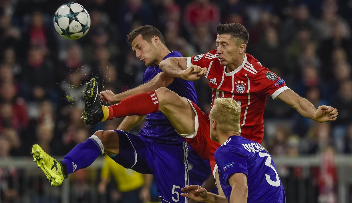 Striker Bayern Munchen, Robert Lewandowski, berebut bola dengan bek Anderlecht, Uros Spajic, pada laga Liga Champions di Stadion Allianz Arena, Munchen, Selasa (12/9/2017). Munchen menang 3-0 atas Anderlecht. (AFP/Guenter Schiffmann)