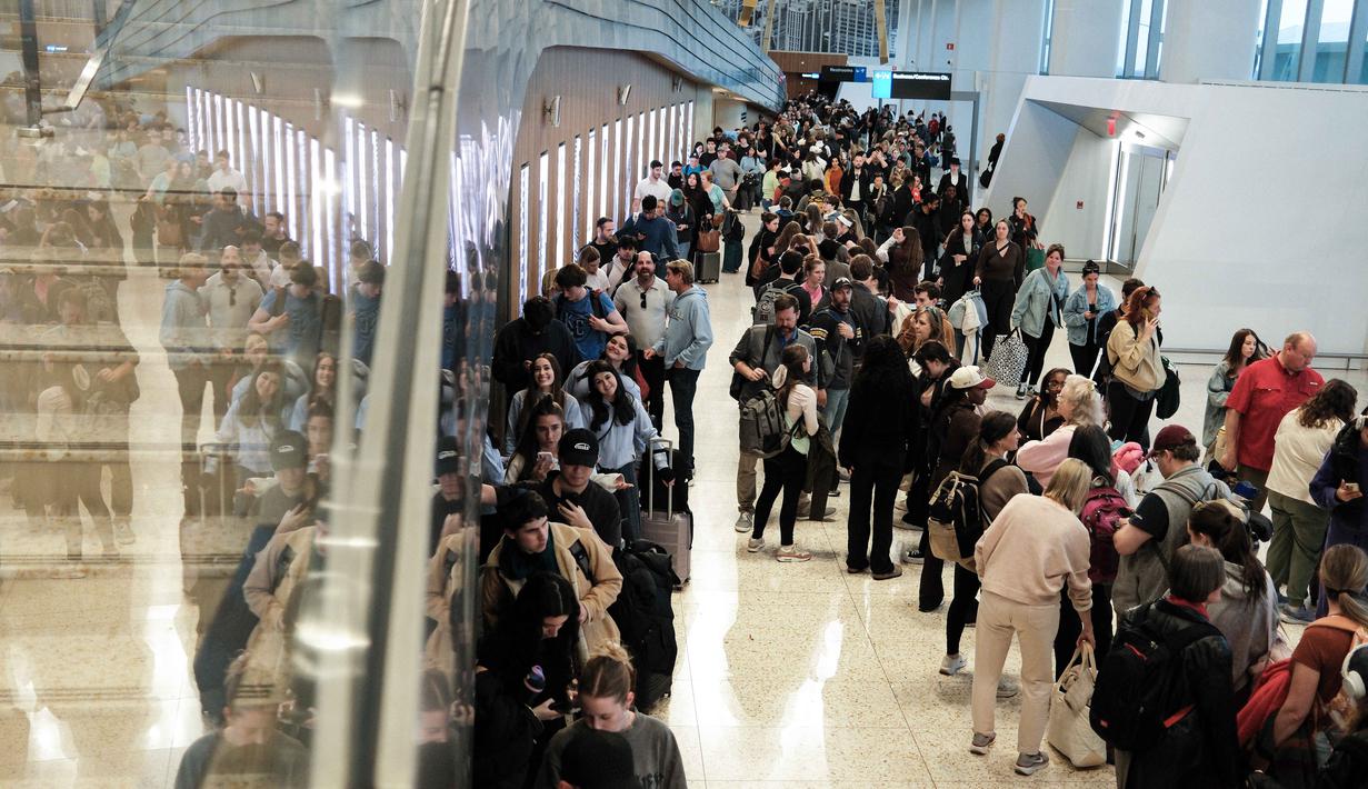 Hal ini untuk membantu mengurai antrean penumpang yang kian memanjang. Tampak dalam foto, antrean para penumpang untuk melewati pemeriksaan keamanan di Bandara LaGuardia, New York pada Minggu 22 Maret 2026. (CHARLY TRIBALLEAU/AFP)