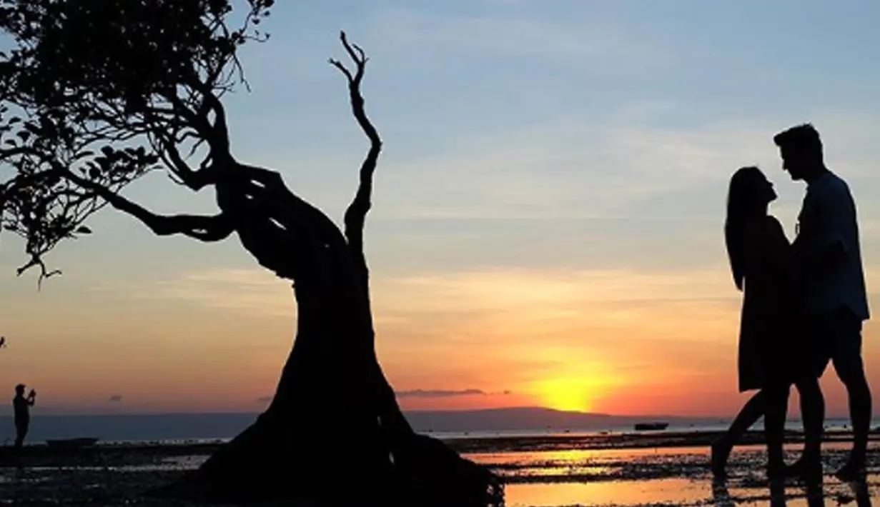 Pasangan yang telah menikah selama 10 tahun ini berfoto dengan latar belakang pemandangan matahari tenggelam. (Liputan6.com/IG/titi_kamall)