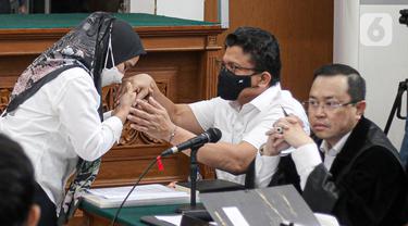 Susi mencium tangan terdakwa Ferdy Sambo sebelum menjadi saksi dalam sidang lanjutan kasus pembunuhan berencana Brigadir Nofriansyah Yosua Hutabarat atau Brigadir J di Pengadilan Negeri Jakarta Selatan, Selasa (8/11/2022). ART keluarga Ferdy Sambo, Susi, kembali menjadi saksi di sidang lanjutan tersebut. (Liputan6.com/Faizal Fanani)