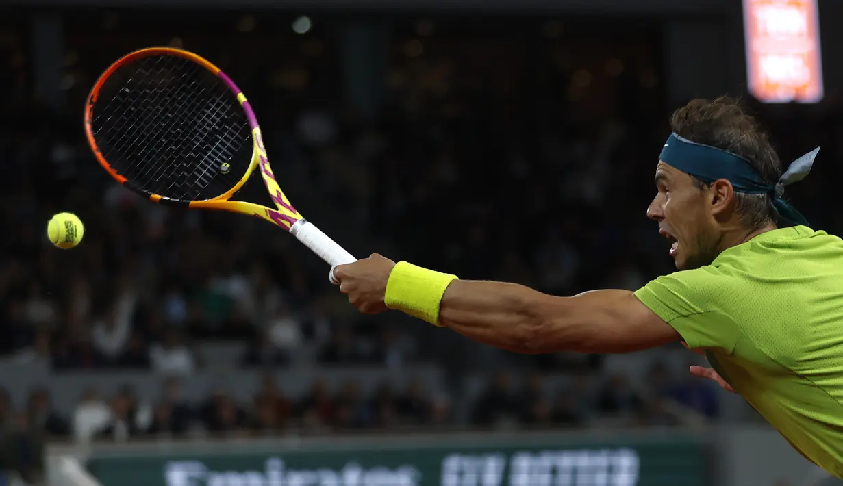 Petenis Spanyol, Rafael Nadal berusaha mengembalikan bola pukulan Novak Djokovic dari Serbia dalam pertandingan perempat final turnamen French Open 2022 di stadion Roland Garros di Paris, Rabu (1/6/2022). Nadal berhasil melaju ke semifinal usai mengalahkan Djokovic dengan skor 6-2, 4-6, 6-2, 7-6(4). (AP Photo/Jean-Francois Badias)