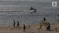 Warga bermain menikmati suasana pantai Ancol saat libur panjang perayaan Waisak 2568 BE, Jakarta, Jumat (24/5/2024). (Liputan6.com/Angga Yuniar)