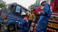 Petugas melakukan pengisian gas ke bajaj menggunakan Mobile Refueling Unit (MRU) atau SPBG Mobile yang baru diresmikan oleh PT Pertamina (Persero) di Lapangan Banteng, Jakarta, Senin (16/11). (Liputan6.com/Faizal Fanani)