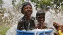 Dua anak berendam mendinginkan tubuhnya saat gelombang panas menerjang di pinggiran Ahmedabad, India, (28/5/2015). Gelombang panas di India telah menewaskan sedikitnya 1.371 karena suhu meningkat di atas 47 Celcius. (REUTERS/Amit Dave)