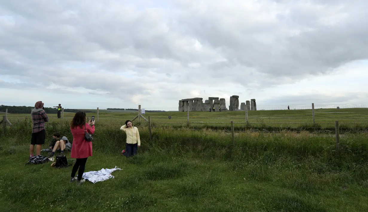 Orang-orang mengabadikan foto di situs warisan dunia Stonehenge di Wiltshire, Inggris (20/6/2020). Sebuah lingkaran yang terdiri dari lubang-lubang prasejarah yang dalam ditemukan di dekat situs warisan dunia tersebut. (Xinhua/Tim Ireland)