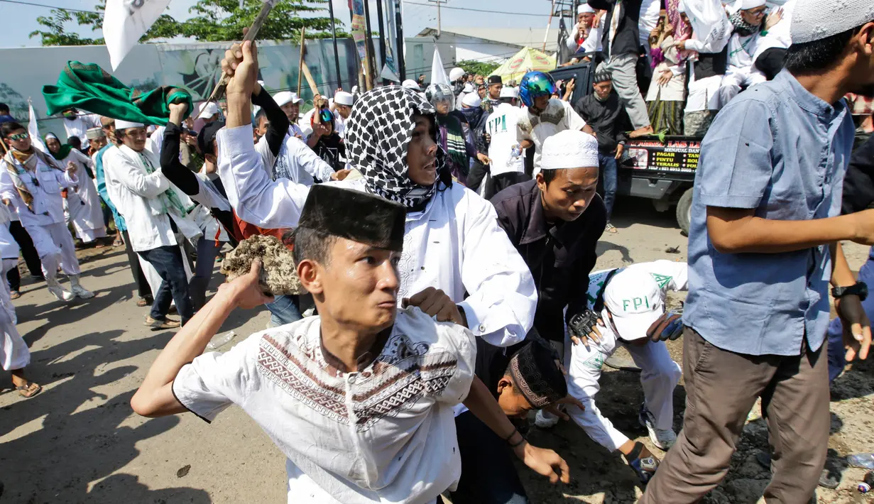 Massa saat terlibat bentrok dengan aparat kepolisian di depan Gereja Katolik Santa Clara, Bekasi, Jawa Barat (24/3). Aksi bentrokan tersebut membuat sejumlah aparat kepolisian dan pemuda Ormas Islam terluka. (AP Photo/Achmad Ibrahim)