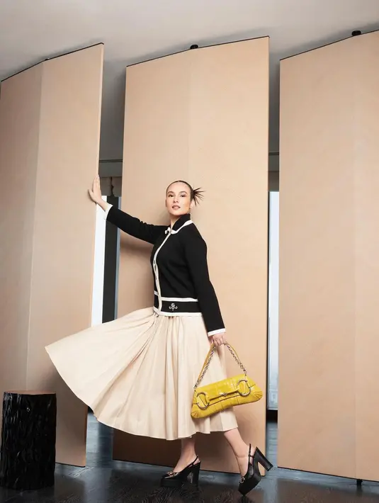 Chelsea Islan kenakan kemeja knit hitam dengan pleated maxi skirt beige. Tas Gucci Horsebit Chain Shoulder Bag jadi sentuhan yang kontras [@chelseislan]