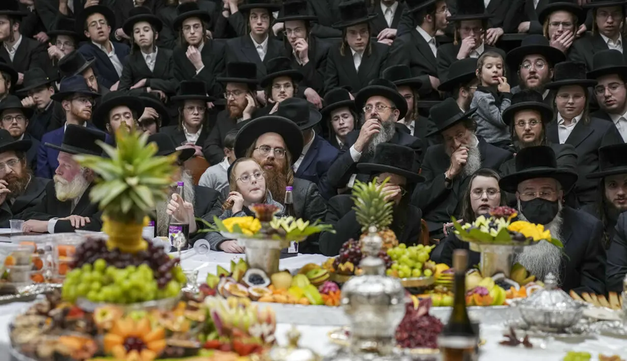 Umat Yahudi ultra-ortodoks dari dinasti Sadigura Hasidic merayakan Hari Raya Tu Bishvat atau Tahun Baru Pohon di Bnei Brak, Israel, 16 Januari 2022. Pada perayaan ini mereka duduk bersama para rabi di sekitar meja panjang dengan hidangan aneka jenis buah-buahan. (AP Photo/Ariel Schalit)
