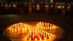 Orang-orang memegang lilin di depan simbol bahaya radiasi di sebuah monumen yang didedikasikan untuk petugas pemadam kebakaran dan pekerja yang meninggal setelah bencana nuklir Chernobyl, menjelang peringatan 40 tahunnya di Slavutych, Ukraina, Sabtu, 25 April 2026. (AP Photo/Dan Bashakov)