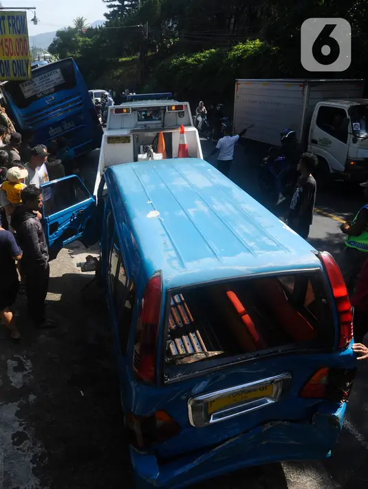 Petugas mengevakuasi angkot yang mengalami kecelakaan di kawasan Cisarua, Bogor, Rabu (28/6/2023). (merdeka.com/Arie Basuki)
