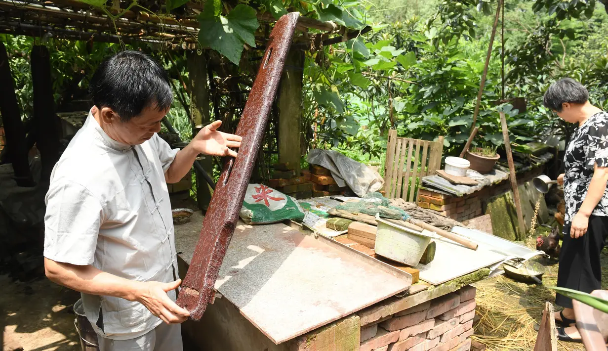 Ma Yuesi (kiri) mengecek Guqin, alat musik tradisional China, di kediamannya di Desa Yalan, Distrik Yuhang, Hangzhou, Provinsi Zhejiang, China timur, pada 30 Juni 2020. Ma Yuesi (58) memutuskan menjadi pembuat Guqin sejak berusia 24 tahun. (Xinhua/Weng Xinyang)