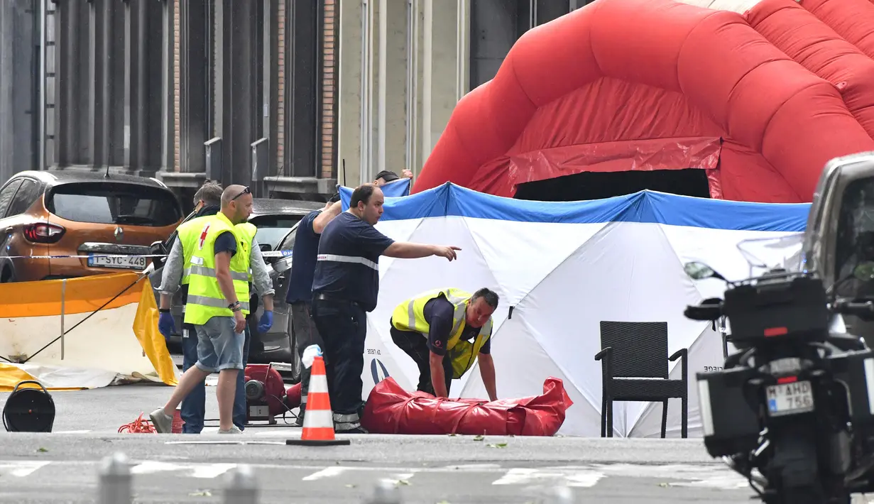 Polisi forensik mengevakuasi jenazah korban penembakan di Liege, Belgia (29/5). Pelaku kemudian ditembak mati polisi. Belum jelas apa motif pelaku. (AP/Geert Vanden Wijngaert)