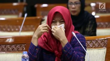 Terpidana kasus pelanggaran UU ITE sekaligus korban pelecehan seksual Baiq Nuril menangis saat hadir dalam rapat pleno Komisi III DPR di Gedung Nusantara III, Jakarta, Rabu (23/7/2019). Rapat membahas surat pertimbangan amnesti dari Presiden Joko Widodo. (Liputan6.com/JohanTallo)