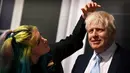 Artis Emma Meehan memberikan sentuhan akhir pada patung lilin PM Inggris Boris Johnson saat sesi pemotretan untuk pembukaannya di Madame Tussauds di Blackpool, Selasa (22/3/2022). Sosok Boris Johnson diletakkan di depan replika pintu depan Downing Street nomor 10 yang terkenal. (Paul ELLIS/AFP)