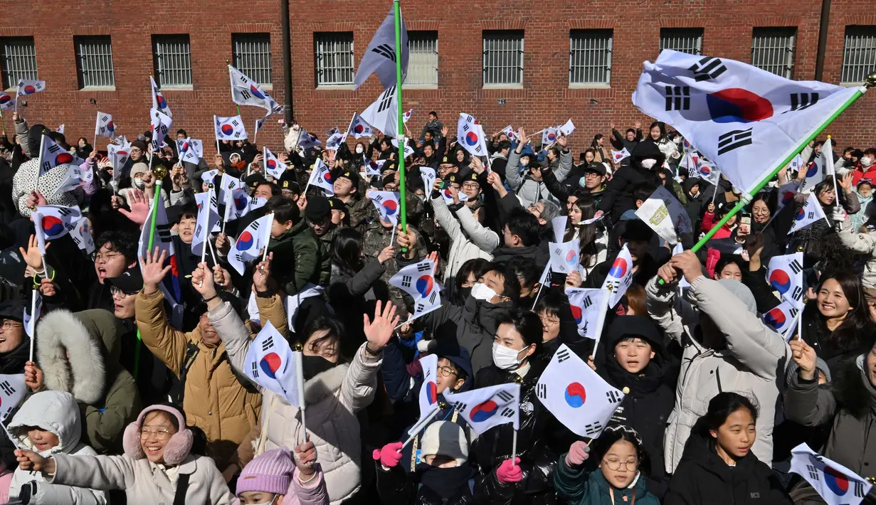Warga melambaikan bendera Korea Selatan dalam upacara yang menandai peringatan 105 tahun Hari Gerakan Kemerdekaan 1 Maret melawan pemerintahan kolonial Jepang, di Aula Sejarah Penjara Seodaemun di Seoul pada tanggal 1 Maret 2024. (Jung Yeon-je/AFP)