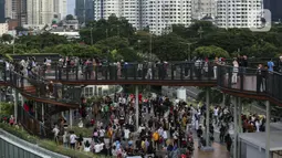 Warga memenuhi Skywalk Senayan Park untuk mengisi libur Tahun Baru dengan menikmati pemandangan Kota Jakarta, Sabtu (1/1/2022). Skywalk Senayan Park kini menjadi salah satu tempat wisata pilihan warga Jakarta lantaran pemandangannya yang instagramable. (Liputan6.com/Johan Tallo)