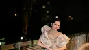 Pesona bak princess Lyodra pakai outfit manggung tanpa lengan bernuansa emas. Dress ini dipenuhi payet berkilauan, dengan detail atasan bustier yang disambung rok mermaid panjang dan tube seperti ombak sebagai outer. [Foto: Instagram/lyodraofficial]