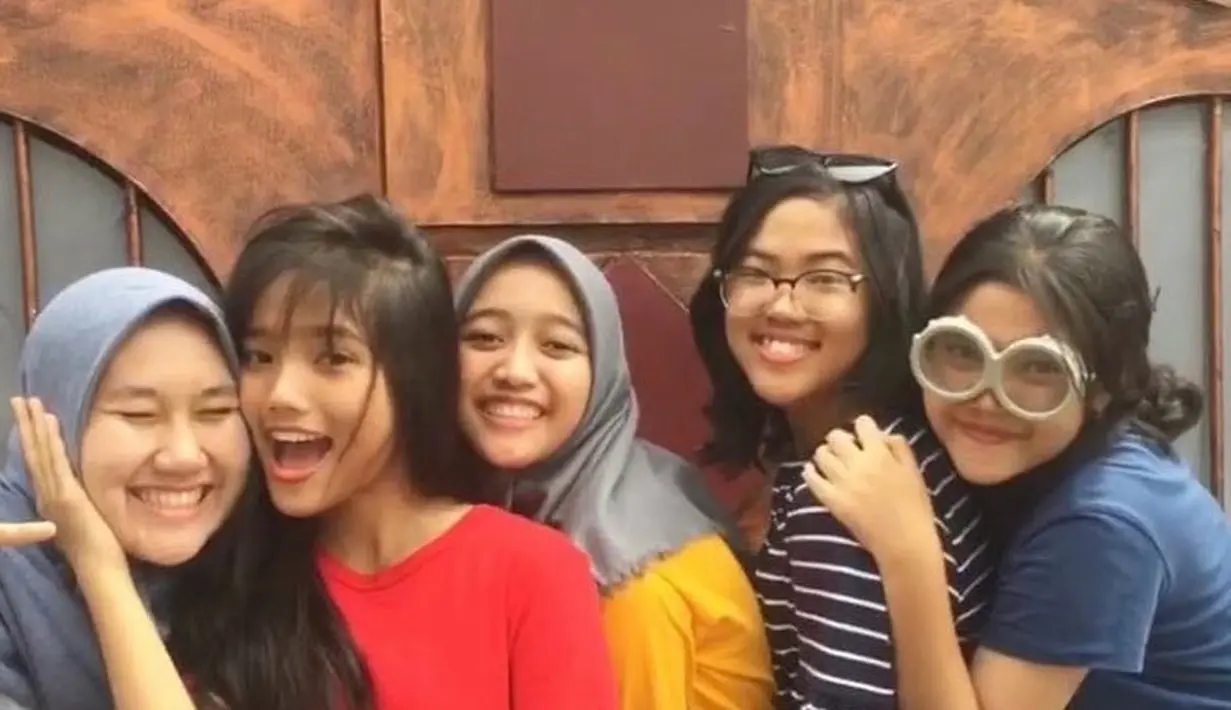 Fuji di tahun 2018 mengenakan kaos merah lengan pendek model kerah v neck. Dengan rambut panjang yang terurai berponi tipis. [@fuji_an]