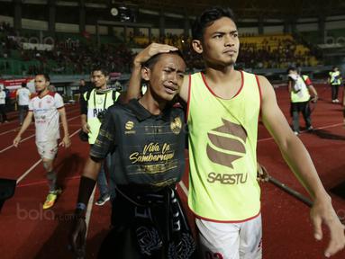 Gelandang Persis Solo, Bayu Nugroho, menenangkan suporter yang menangis usai takluk dari Kalteng Putra FC pada laga Liga 2 di Stadion Patriot, Bekasi, Senin (13/11/2017). Persis Solo kalah 0-1 dari Kalteng Putra FC. (Bola.com/M Iqbal Ichsan)