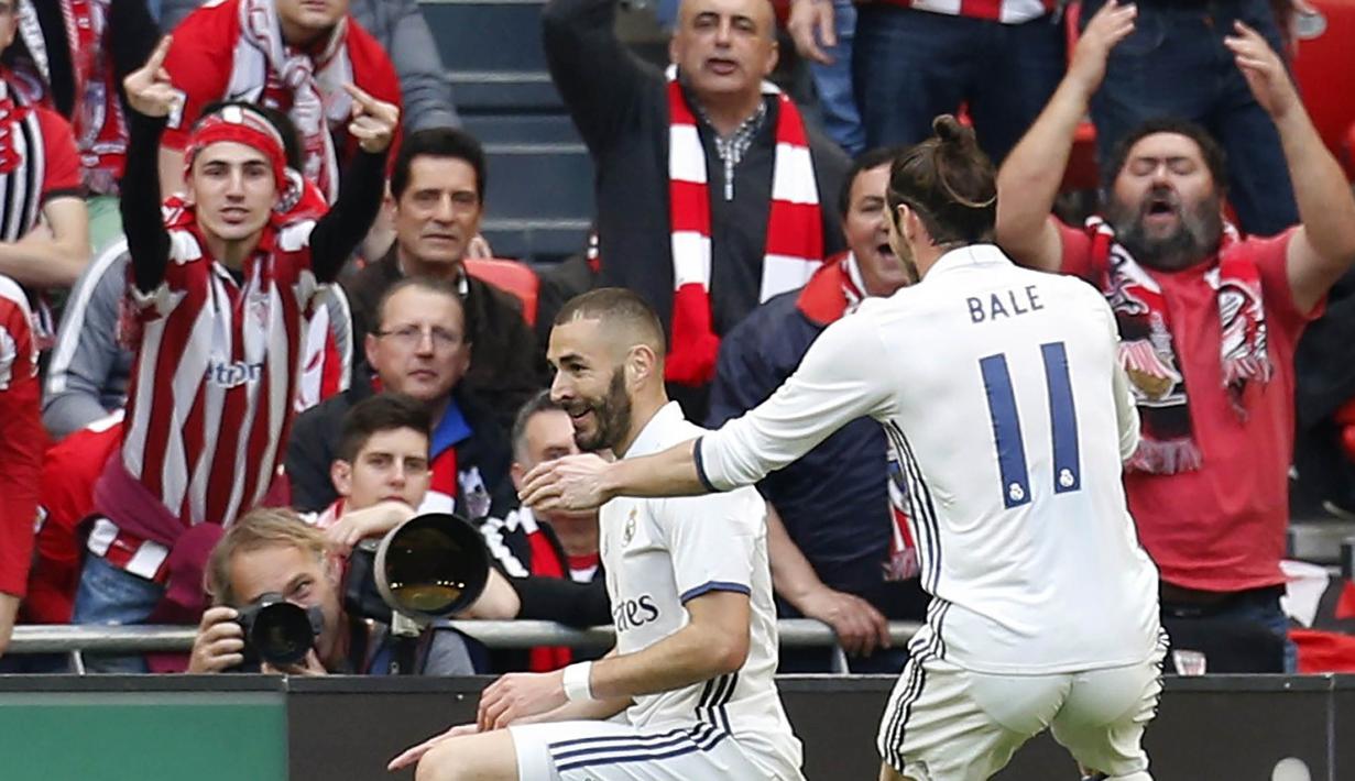 Striker Real Madrid asal Perancis, Karim Benzema, merayakan gol nya di depan suporter Athletic Bilbao. Kemenangan ini membuat El Real menjadi tim kedua setelah Barcelona, yang membawa pulang tiga poin dari markas Bilbao. (EPA/Luis Tejido)
