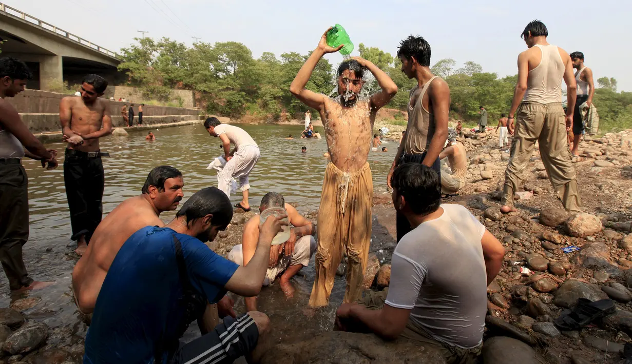 Sejumlah orang terlihat mandi di sungai saat cuaca panas yang ekstrem di Islamabad, Pakistan, (23/6/2015). Gelombang panas membuat warga Pakistan tak bisa jauh dari air untuk bertahan hidup. (REUTERS/Faisal Mahmood)