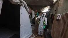 Seorang pengungsi Palestina menyemprotkan cairan disinfektan pada jalan setapak dan tenda-tenda untuk membasmi serangga dan hewan pengerat di kamp pengungsian Khan Yunis, Jalur Gaza Selatan pada Rabu 22 April 2026. Krisis kemanusiaan di Gaza kian memburuk. (Bashar Taleb/AFP)