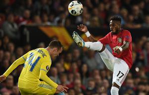 Gelandang Manchester United, Fred, menghindari penjagaan bek Astana, Luka Simunovic, pada laga Europa League di Stadion Old Trafford, Manchester, Kamis (19/9). MU menang 1-0 atas Astana. (AFP/Oli Scarff)