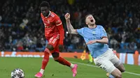 Pemain Bayern Munchen, Alphonso Davies (kiri) melanggar pemain Manchester City, Kevin De Bruyne pada laga leg pertama perempat final Liga Champions 2022/2023 di Etihad Stadium, Manchester, Rabu (12/04/2023) WIB. Meski memiliki kecepatan dalam hal menyerang, Davies terlihat kepayahan ketika harus bertahan. Serangan City acap kali bermula dari area yang dijaga Davies. (AFP/Paul Ellis)